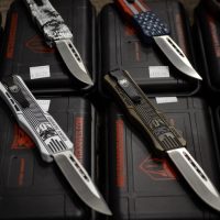 Several folding knives with patterned handles are displayed on black cases, each labeled with a price tag.